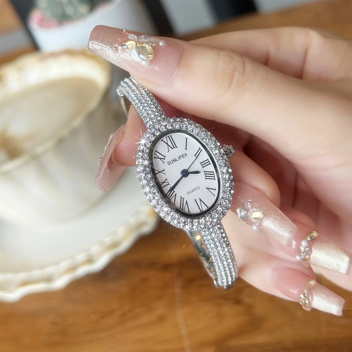 ساعة نسائية فاخرة - ساعة بيضاوية مرصعة بأحجار الراين بأرقام رومانية ومقاومة للماء